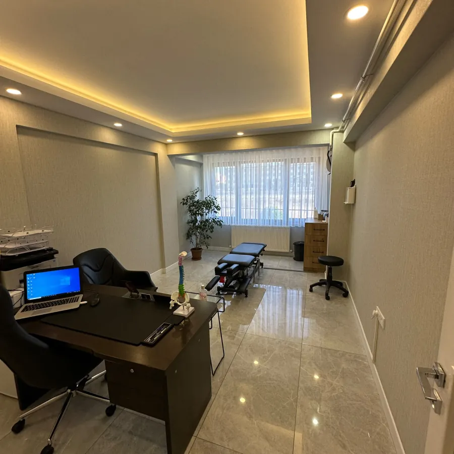 Değerlendirme masası ve tedavi sedyesinin bulunduğu klinik odası